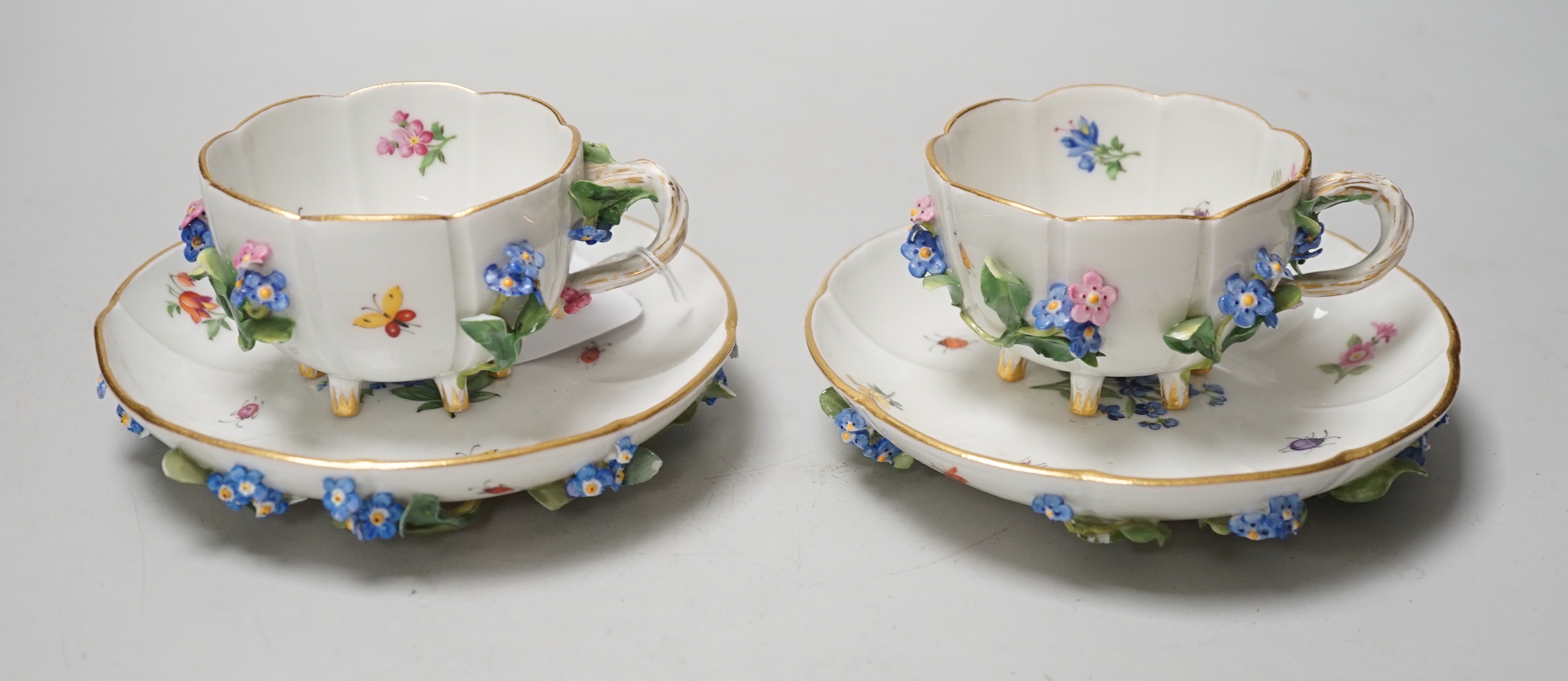 A pair of Meissen floral-encrusted cabinet cups and saucers, late 19th century, saucers 14cm diam.